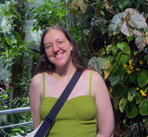 female standing in front of foliage